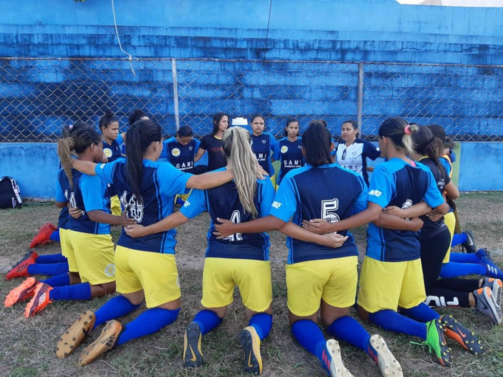 Etapa Nordeste vai ajudar grupo de percussão do Gami, de Natal (RN) foto mostra time de futebol feminino do gami ajoelhadas fazendo oração