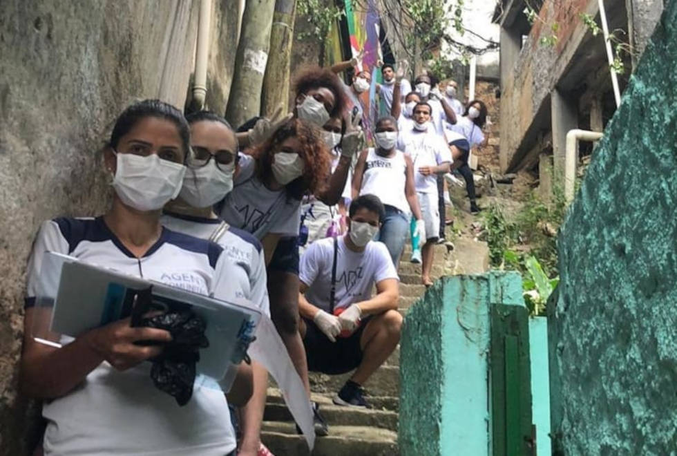 Na segunda etapa, 44 tablets foram comprados a crianças da Rocinha foto mostra voluntários da rocinha resiste em uma escadaria da comunidade