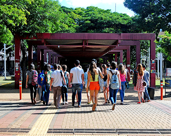 Todos os que tiverem retorno previsto devem passar por testagem, videoaulas e responder a inquérito de saúde do aplicativo AVISU foto mostra alunos de costas andando em direção ao restaurante universitário da unicamp