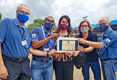 A SVC tem colaborado ostensivamente para divulgar e apoiar as ações do Conseg no sentido de conscientizar a comunidade do entorno da Unicamp sobre a pandemia Funcionários da SVC segurando o diploma de Honra ao Mérito e comemoram homenagem