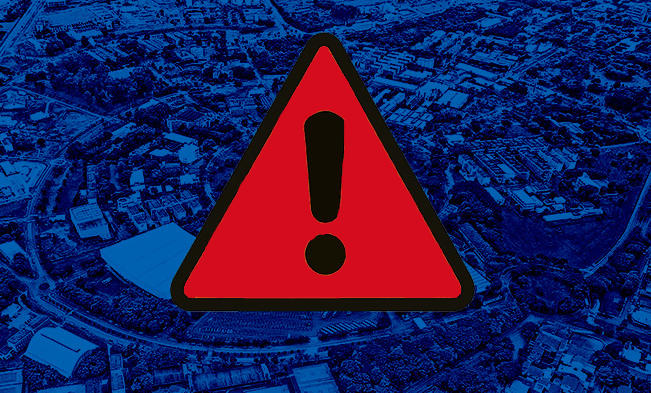 audiodescrição: imagem colorida: ao fundo imagem aérea do campus de campinas colorida em  tom azul, sobre ela imagem do símbolo de exclamação em preto sobre um triângulo vermelho.