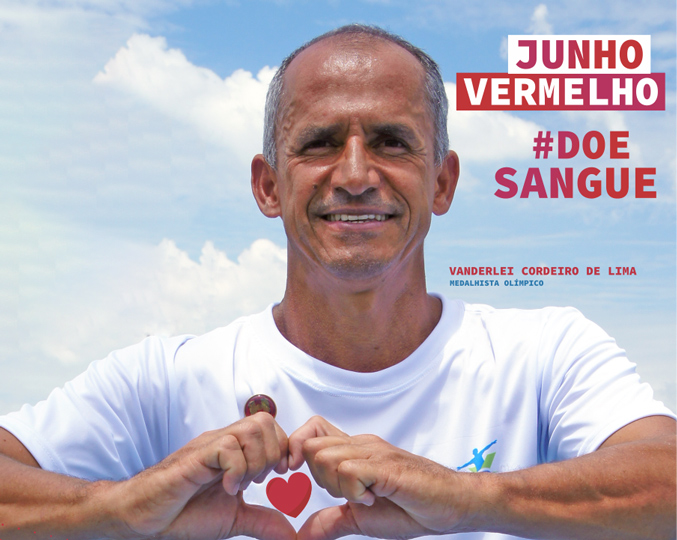 foto mostra o maratonista vanderlei cordeiro fazendo um coração com as mãos e o texto "junho vermelho doe sangue"