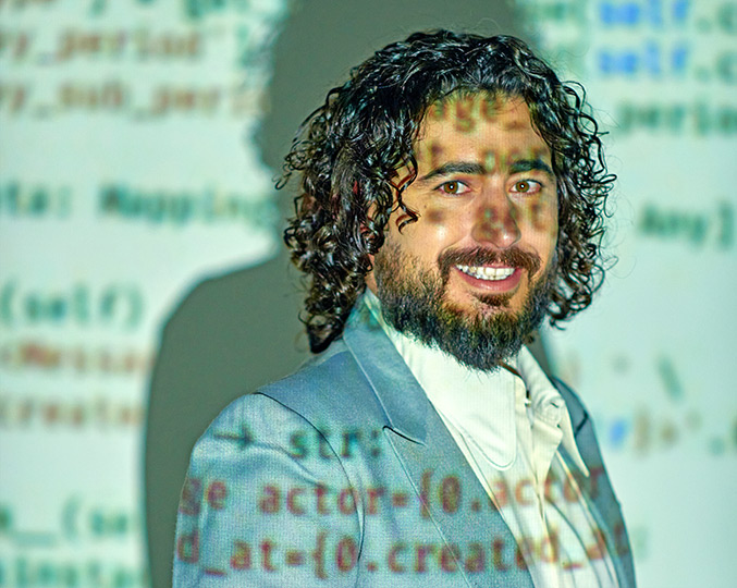 audiodescrição: fotografia colorida do pesquisador fernando cavalcante; sobre ele há uma projeção do código do software qualichat