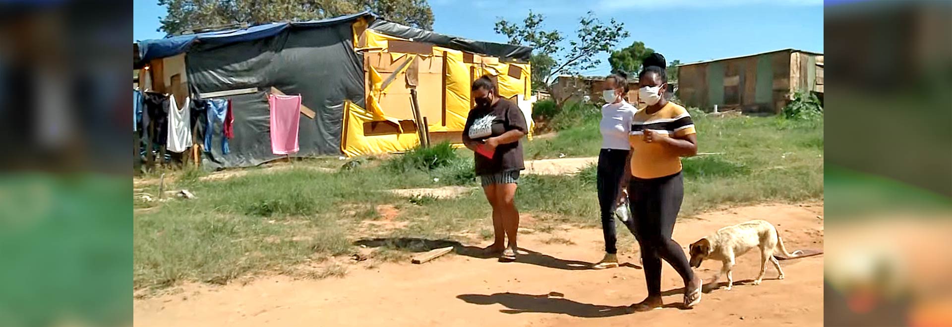 foto mostra repórter liana coll e duas moradoras da periferia de campinas andando por uma rua do bairro. as três usam máscaras