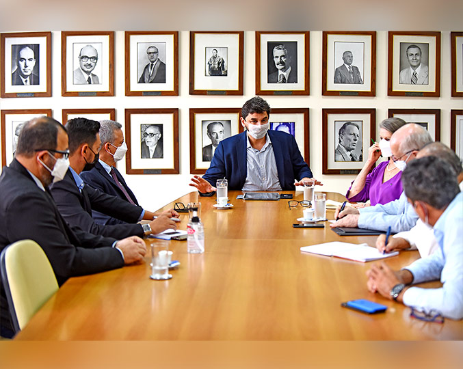 Eduardo Ribeiro Adriano diz que nova unidade deve contribuir para a reorganização da assistência à saúde na região (foto: Antonio Scarpinetti) foto mostra representantes da unicamp e da região metropolitana de campinas sentados à mesa com o secretário executivo de saúde na cabeceira