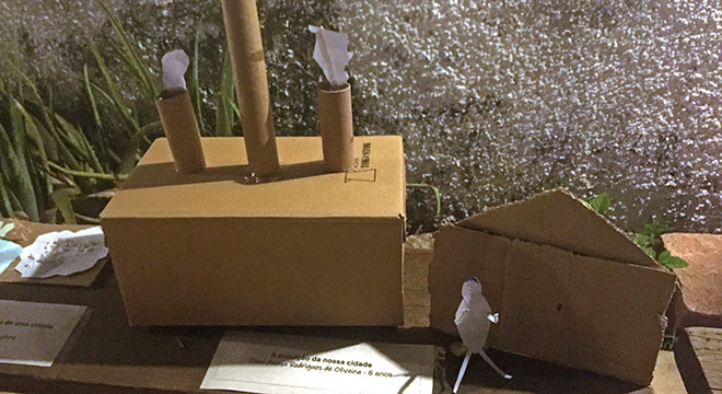 foto mostra maquete feita com sucata simulando uma fábrica com chaminés