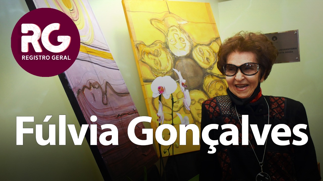 foto mostra fúlvia gonçalves no primeiro plano e as telas doadas à unicamp ao fundo