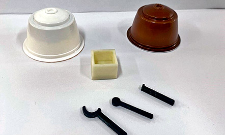 Cápsulas usadas e algumas peças produzidas por meio de impressão 3D Cápsulas usadas e algumas peças produzidas por meio de impressão 3D