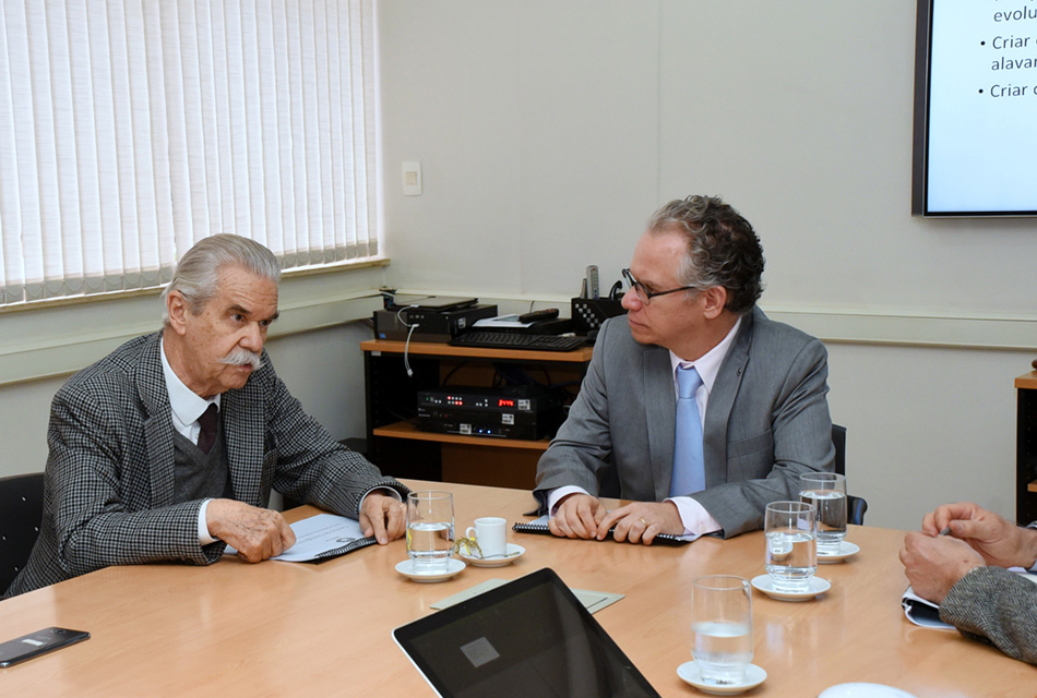 O secretário estadual de Energia e Mineração do Estado de São Paulo, João Carlos Meirelles (à esquerda), e o reitor da Unicamp, Marcelo Knobel, durante visita à Universidade A galeria apresenta o encontro entre o reitor da Unicamp, Marcelo Knobel, e o secretário estadual de Energia e Mineração do Estado de São Paulo, João Carlos Meirelles, e suas equipes. Para acessar a galeria, tecle enter. Descritivo: em sala de reuniões, dois homens sentados em cadeiras, uma ao lado do outro, na cabeceira e na lateral da mesa retangular de madeira que se encontra à frente deles, onde apoiam os braços. Na mesa há um notebook aberto e copos de vidro. Eles vestem terno e gravata. Imagem 1 de 4.