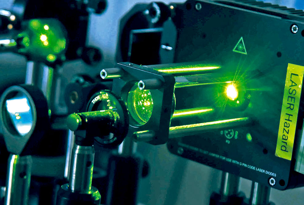 Foto de um equipamento que está emitindo uma luz verde.