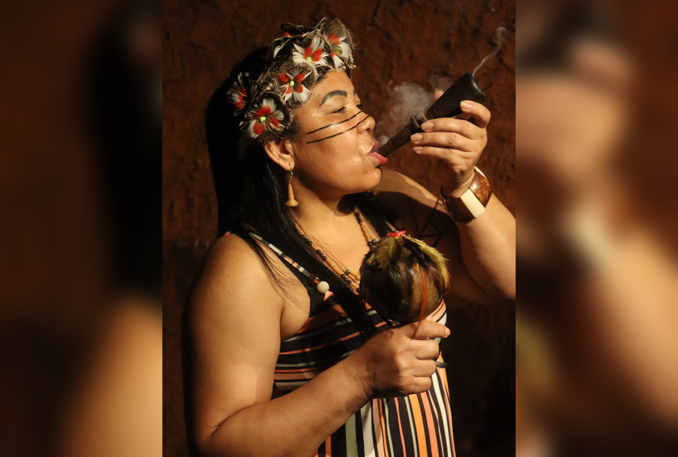 Maria Lídia fumando seu campiô e segurando o maraca: liderança ocupa papel central nas interações