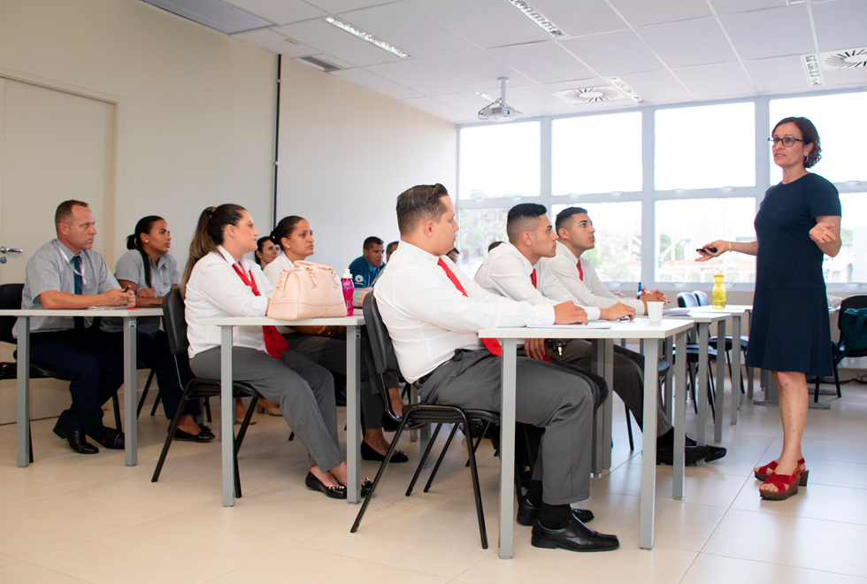 foto mostra uma sala de aula, com vigilantes da secretaria de vivência nos campi sentados em carteiras e a professora susana durão em pé, à frente da sala, expondo um conteúdo