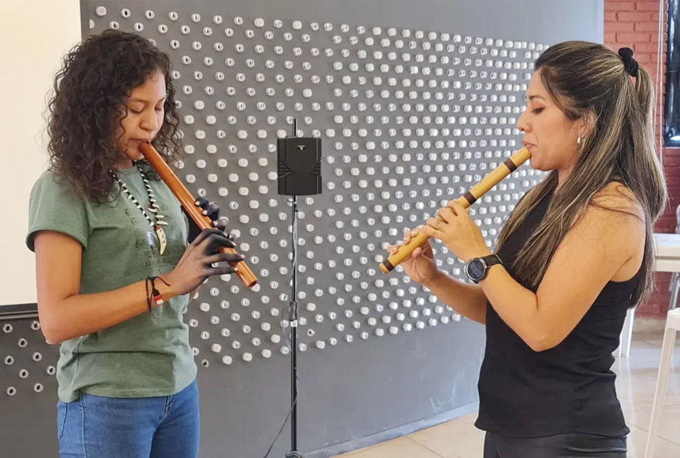foto mostra duas mulheres tocando flauta doce
