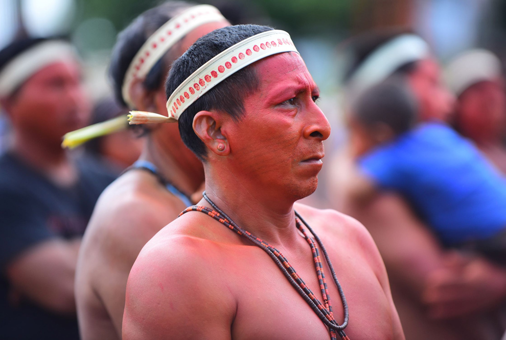 audiodescrição: fotografia colorida de indígenas pintados de urucum