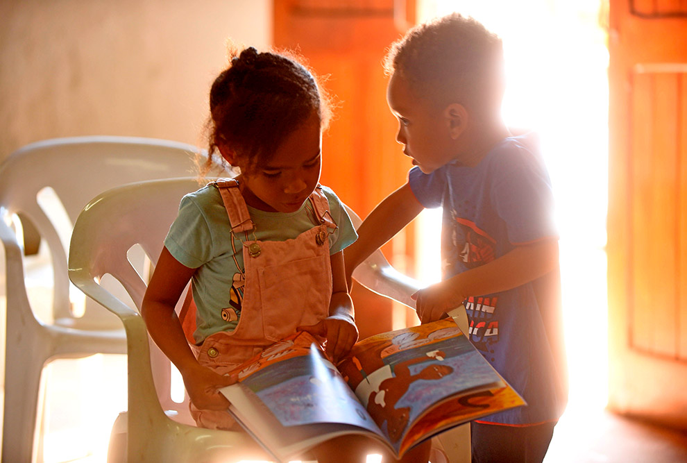 duas crianças negras folheiam um dos livros da autora