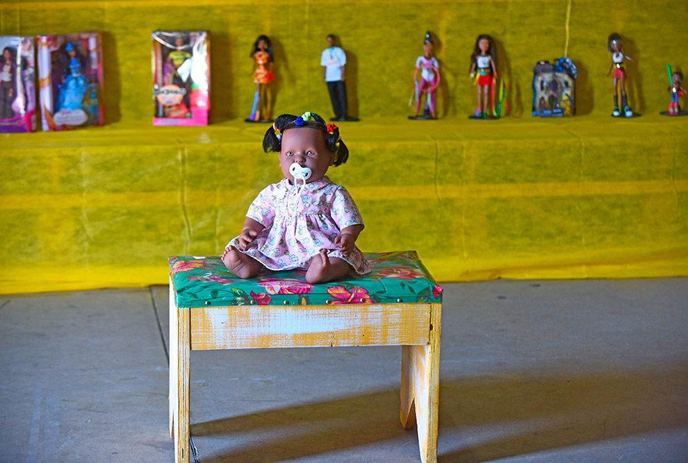 foto de uma boneca que é uma bebê negra, com chupeta, parte da exposição