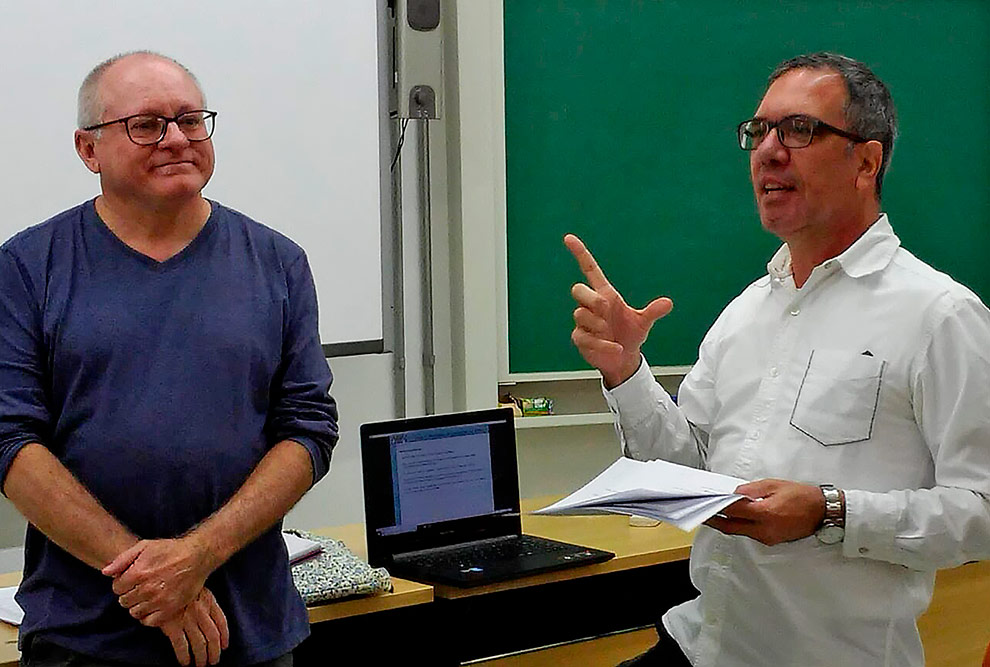 O professor Marcelo aparece à direita falando enquanto Maurício Squarisi ocupa o lado esquerdo do quadro e parece acompanhar o que o professor está dizendo