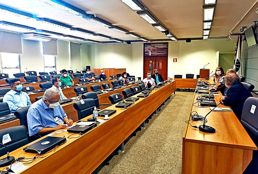 foto mostra sala do conselho universitário com os presentes acompanhando uma apresentação