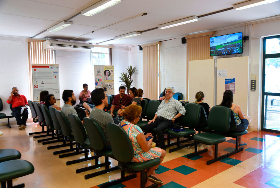 foto mostra a sala de espera do cecom da unicamp com pessoas sentadas em cadeiras aguardado por atendimento