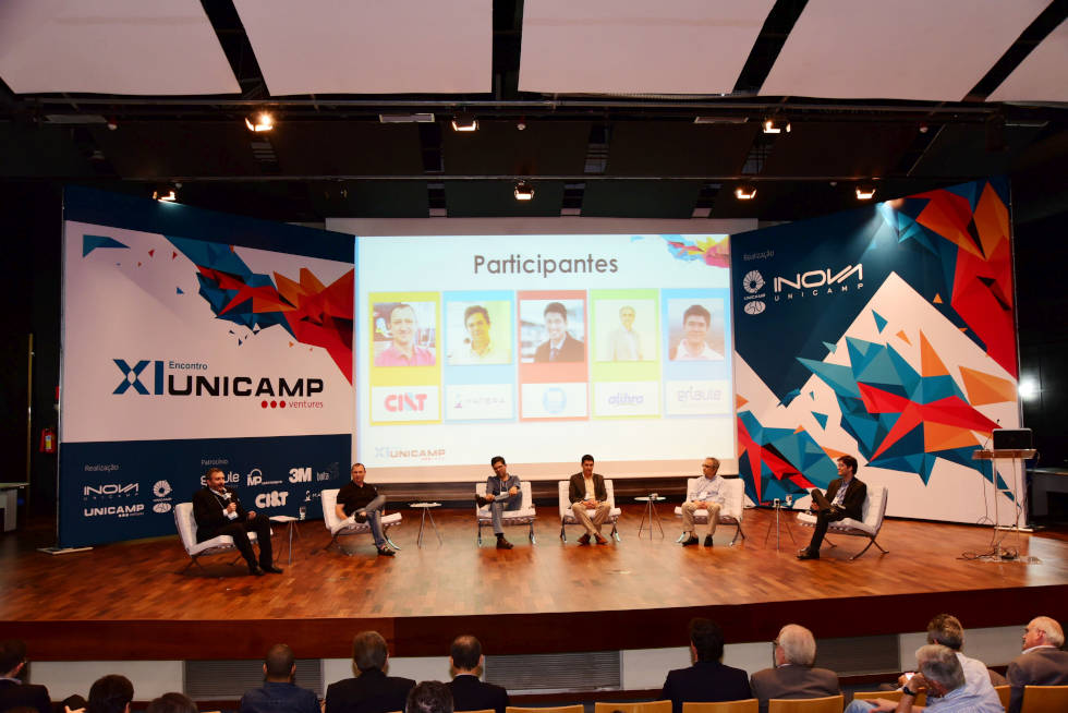 foto mostra palco do evento unicamp ventures com participantes sentados em poltronas