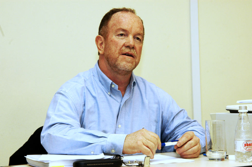 foto mostra o professor claudio dedecca sentado à mesa falando e gesticulando