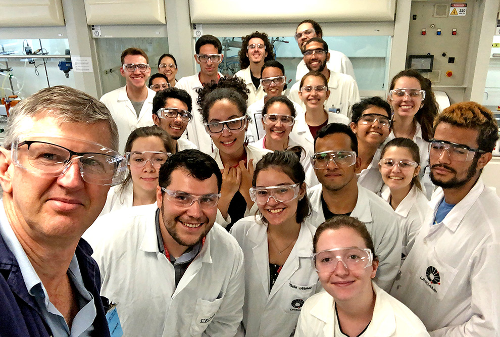 audiodescrição: fotografia colorida do professor edvaldo junto a diversos alunos de jaleco, eles sorriem e posam para a foto