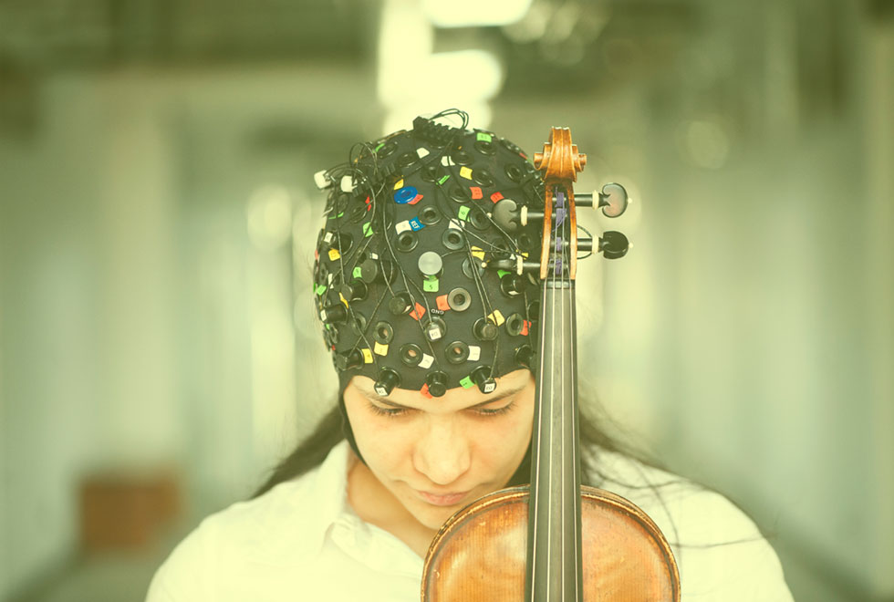 Pesquisadora da UFABC com touca usada para registrar as atividades cerebrais enquanto pratica música