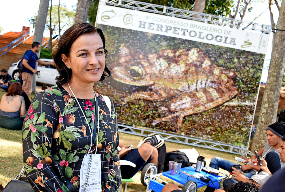 Ana Prudente, em frente ao painel com a foto de um sapo, na parte externa do Congresso