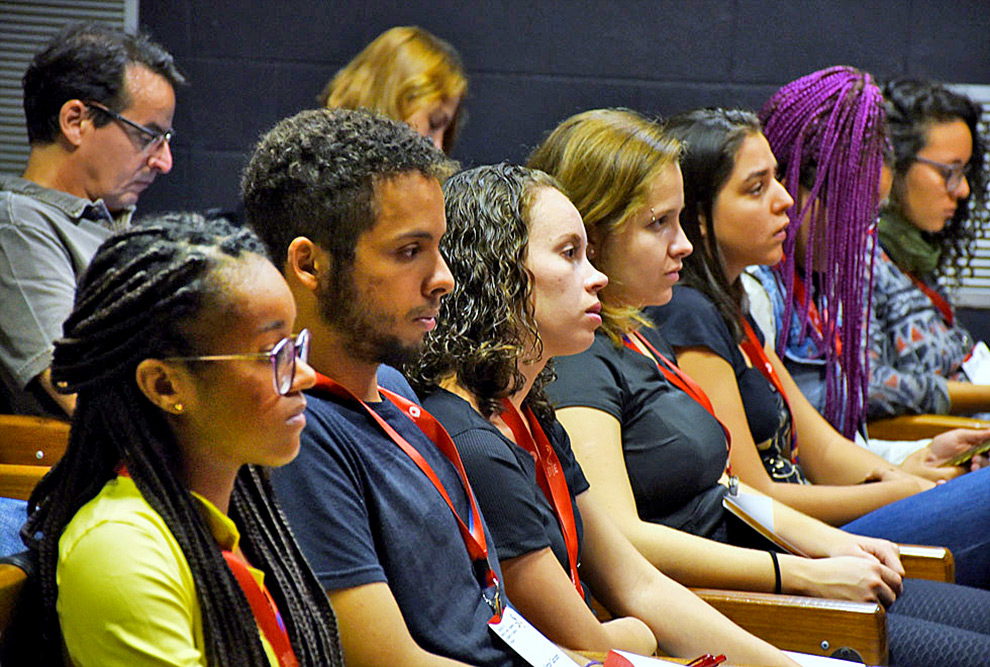 audiodescrição: fotografia colorida de estudantes em um auditório