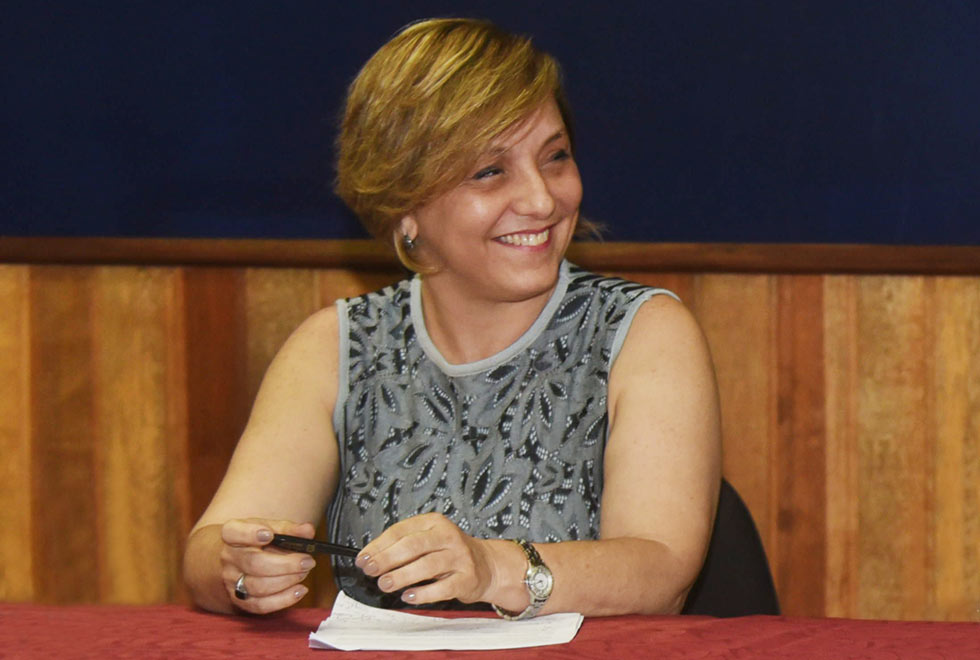 Pró-reitora de Graduação Eliana Amaral sorri, sentada durante evento