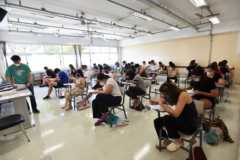 audiodescrição: fotografia colorida de estudantes realizando a prova em uma sala; todos estão de máscara e  concentrados realizando o exame