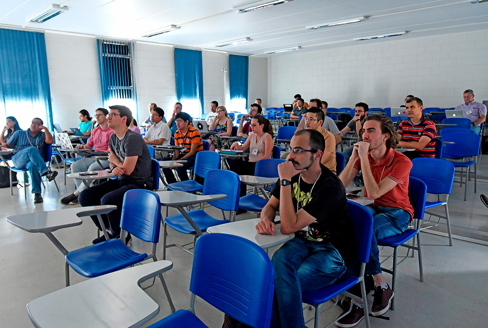 plateia de pesquisadores e alunos sentados prestando atenção na palestra