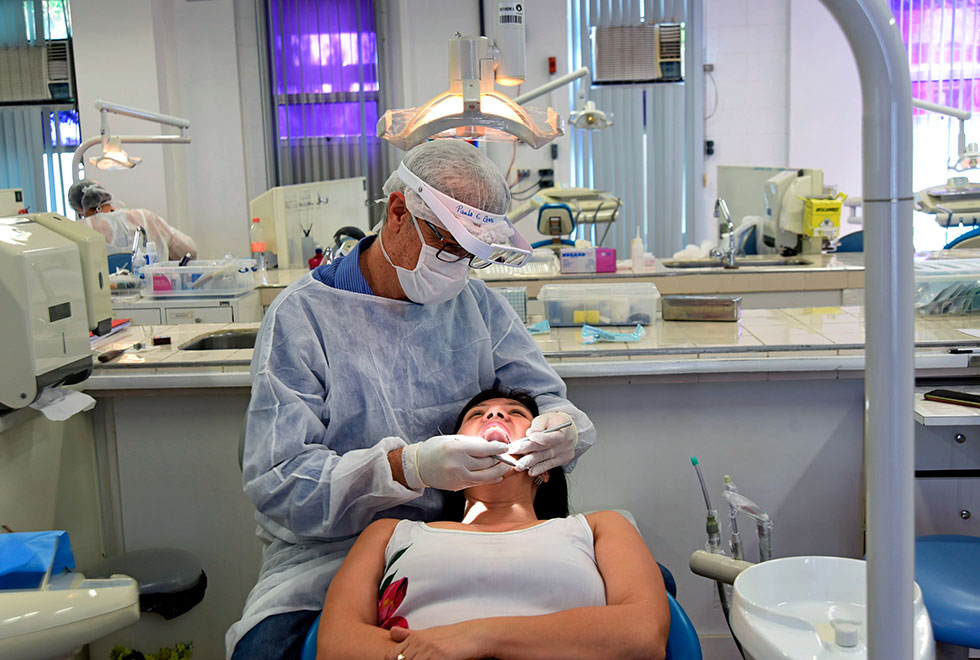 dentista examina boca de paciente