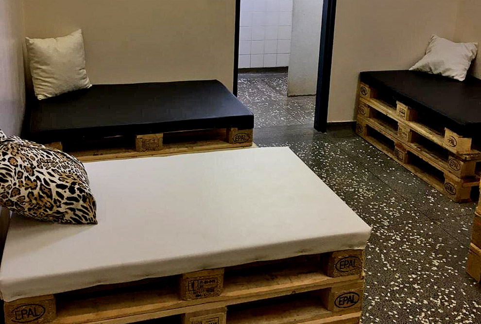 foto mostra duas camas feitas com pallets empilhados e colchões por cima