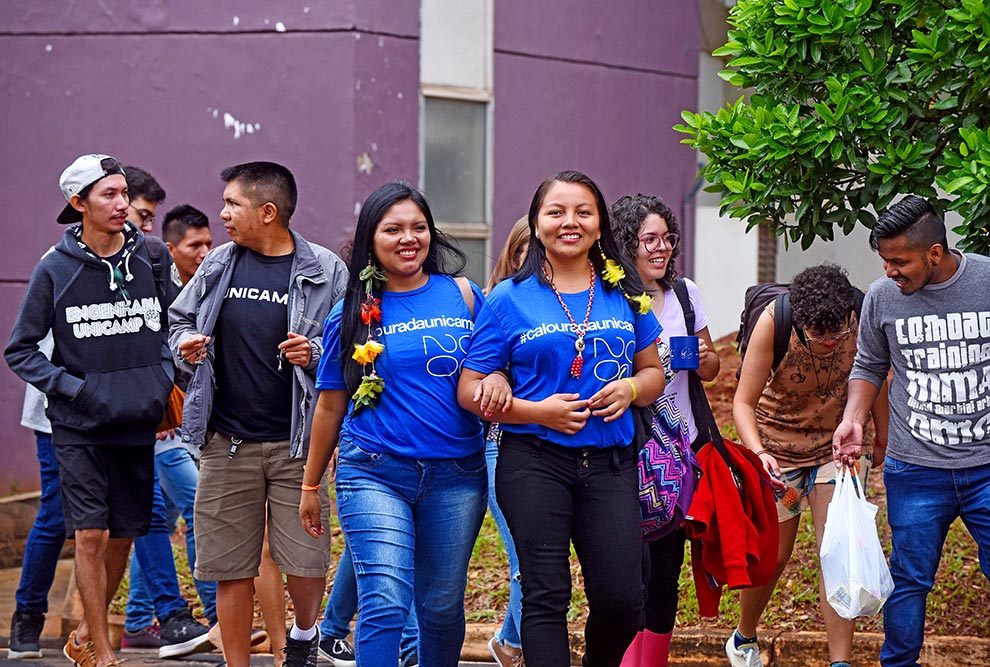 foto mostra grupo de alunos indígenas andando pelo câmpus