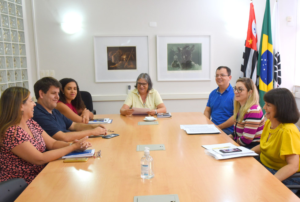 audiodescrição: fotografia colorida mostra mesa de reunião com representantes do comitê de proteção de dados da unicamp