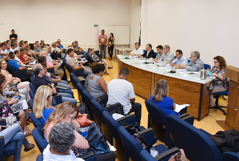 Imagem geral do auditório da FCA. Em primeiro plano a plateia e ao fundo a mesa com reitoráveis e mediadores