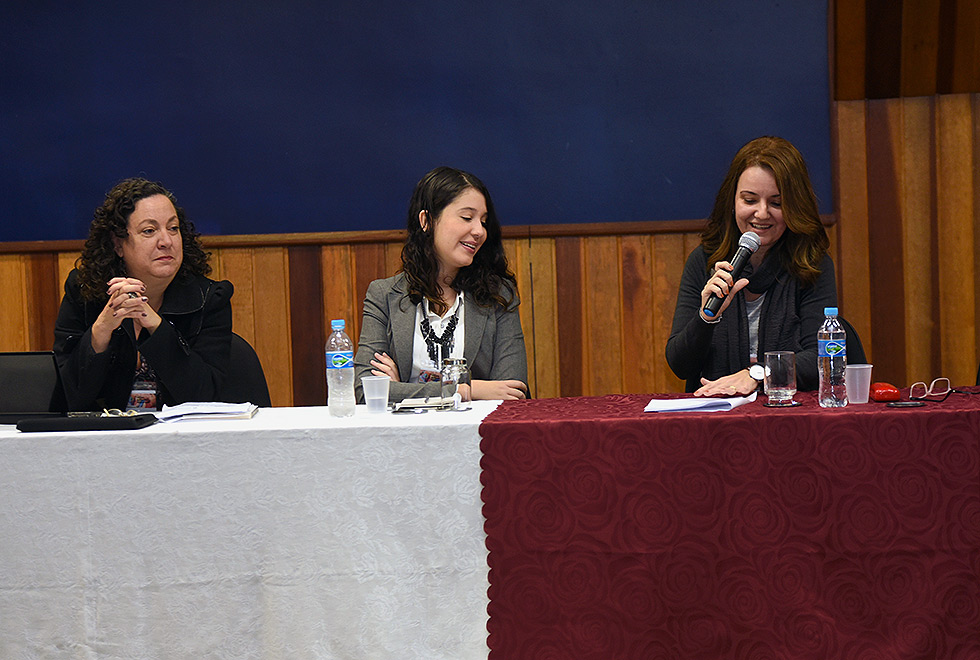 mesa de abertura com três convidadas do evento que conversam entre si