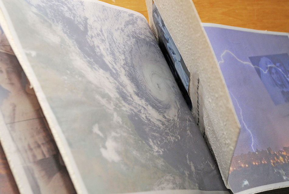 Livro semelhante a algum de fotos antigo entre aberto sobre a mesa deixa ver imagens de fotos antigas e fenomenos metorológicos