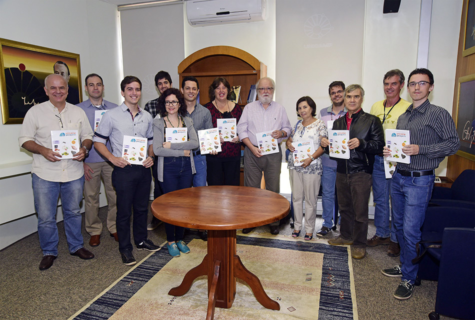 Equipe da pró-reitoria posa para foto com a revista em mãos