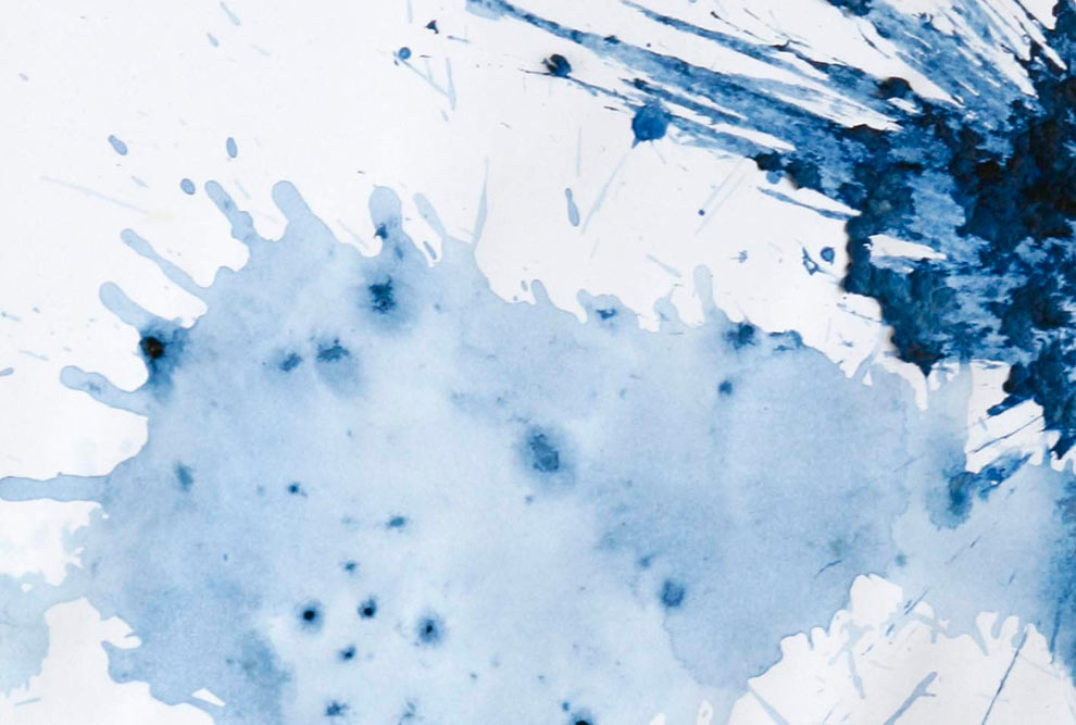 Detalhe da capa de um livro que mostra um líquido azul derramado em uma superfície branca.