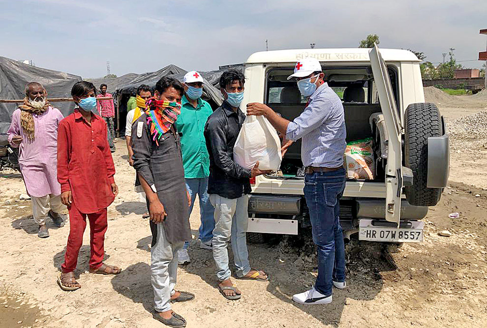 foto mostra voluntários entregando doações a comunidades na índia
