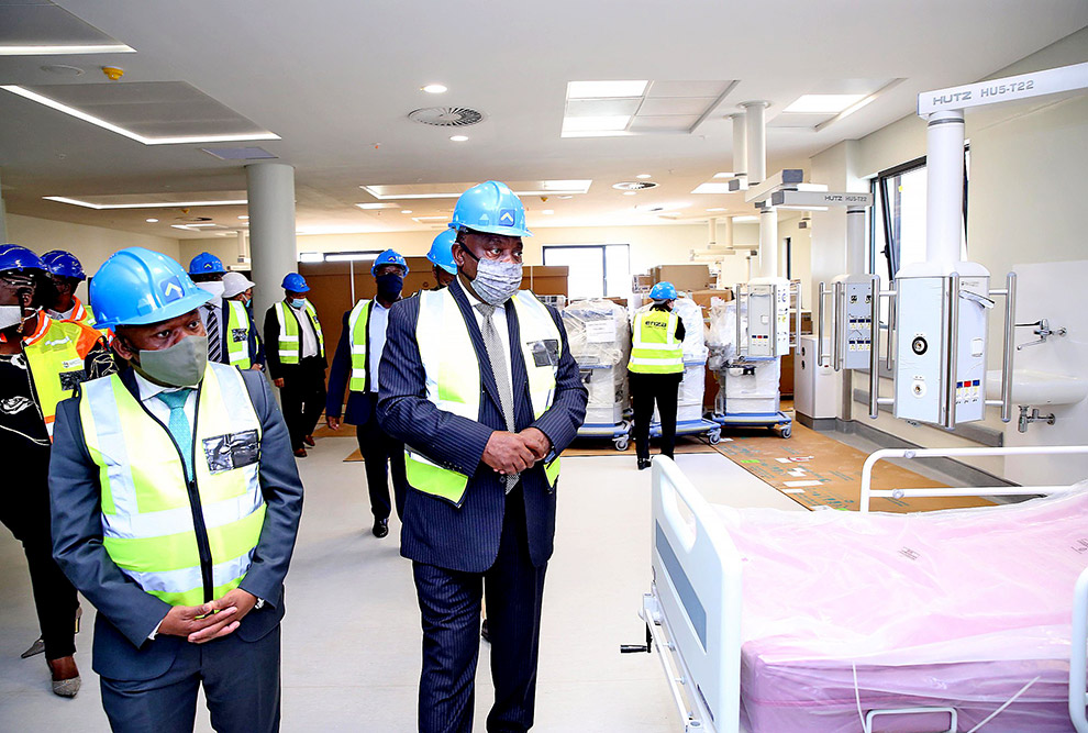 foto mostra presidente da áfrica do sul, com equipamentos de segurança, visitando um hospital