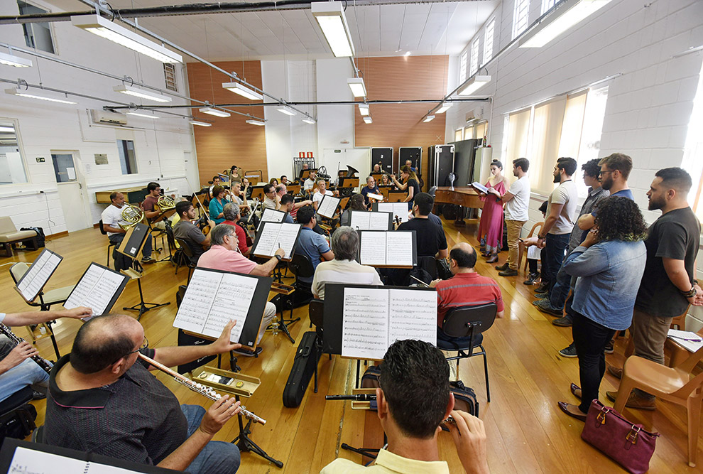 imagem aberta mostra formação da orquestra com a regente e solistas