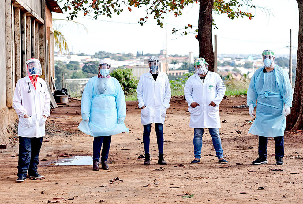 foto mostra membros da força tarefa, vestidos com roupas de segurança