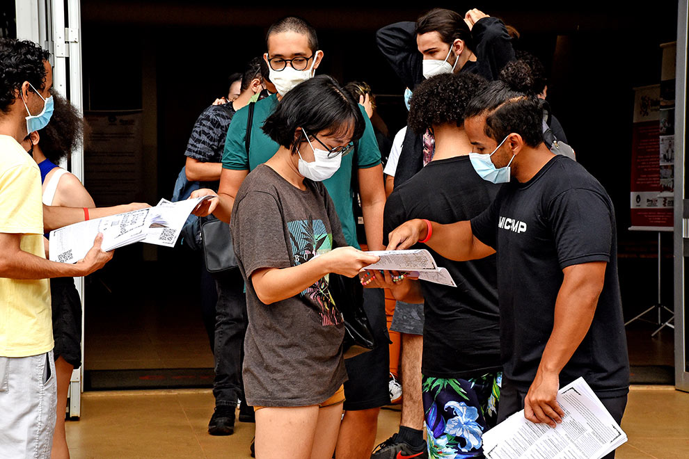foto mostra estudantes olhando um mapa no campus