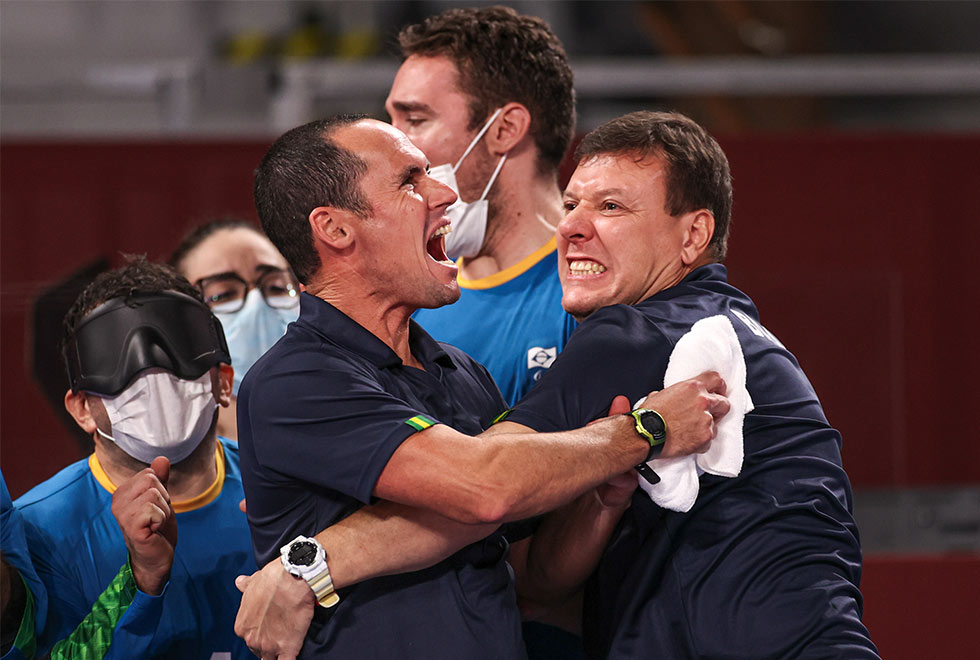 foto mostra alessandro comemorando vitória abraçado com outros jogadores