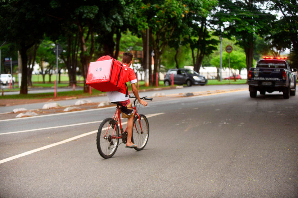 audiodescrição: fotografia colorida de entregador de bicicleta