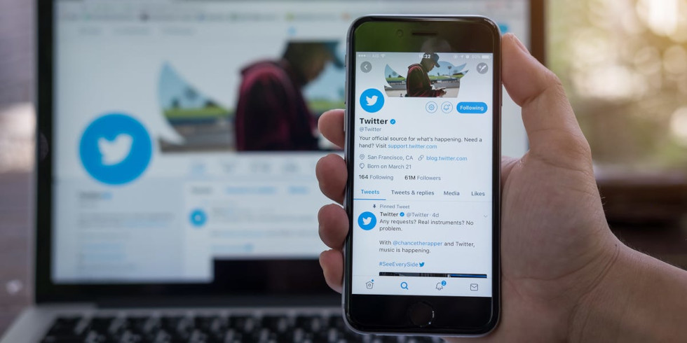 foto mostra uma mão segurando um celular conectado no twitter