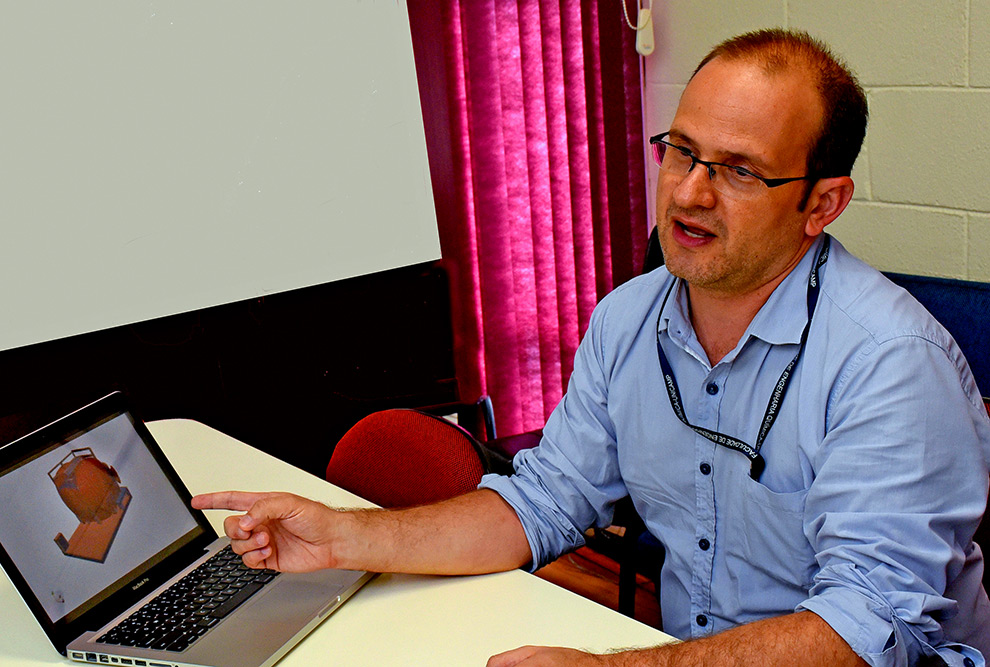 foto mostra o professor sávio vianna em uma mesa, com um arquivo aberto na tela de um computador